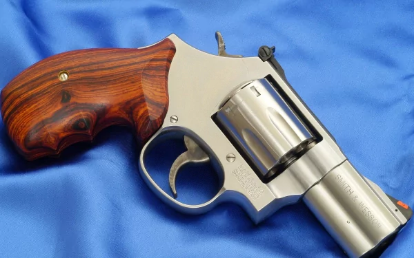 Man-made Smith & Wesson revolver with polished steel frame and rosewood grips resting on blue satin, presented as an HD PC desktop wallpaper and background.