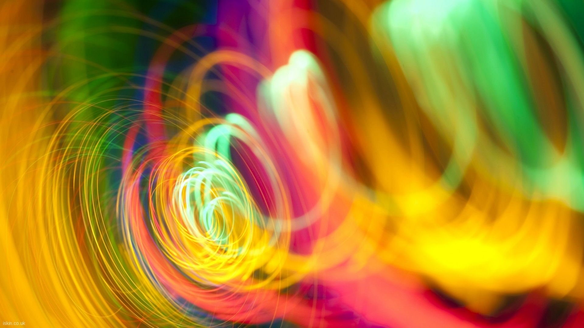 HD PC desktop wallpaper — abstract rainbow swirl of vivid colors and light trails forming a dynamic, soft-focused background.