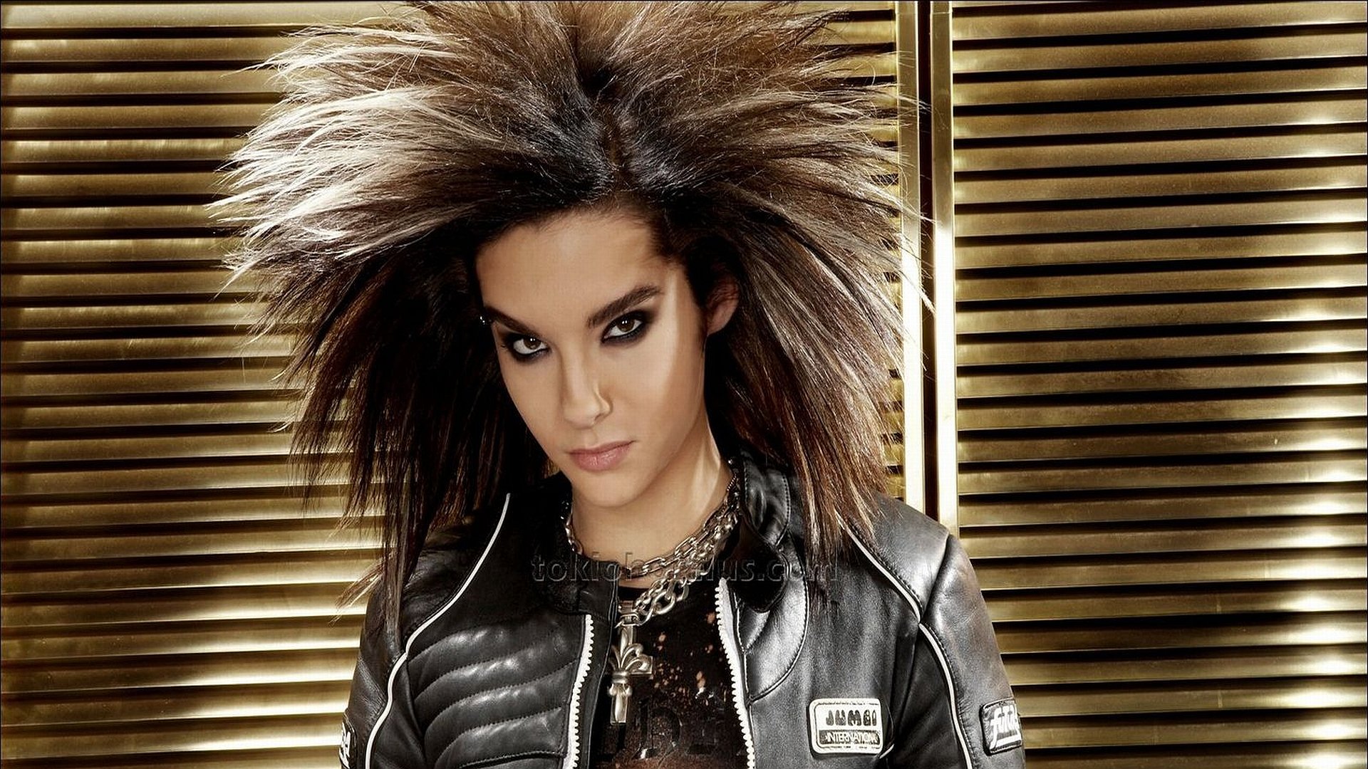 HD PC desktop wallpaper featuring a member of Tokio Hotel with striking spiked hair and intense gaze, set against a textured background, highlighting music and band style.