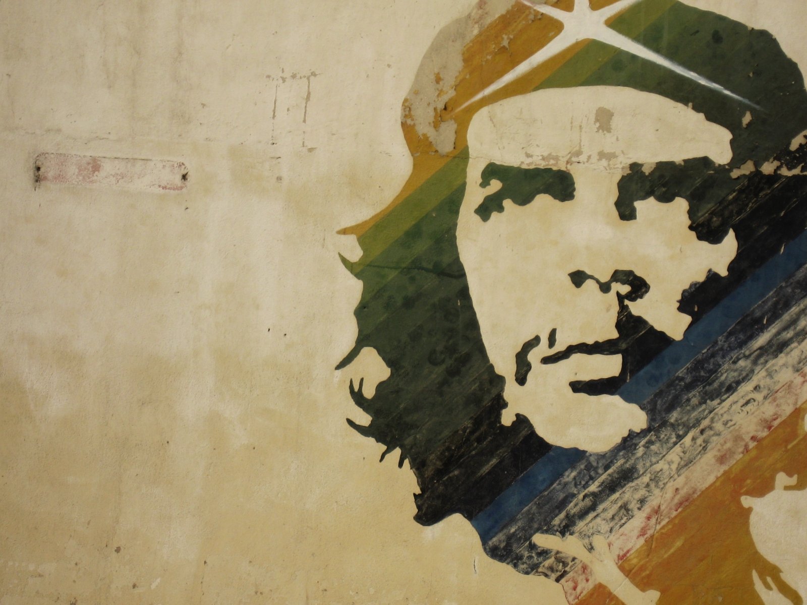 A powerful HD wallpaper featuring a military-themed mural of Che Guevara, showcasing his iconic image against a textured background in earthy tones.