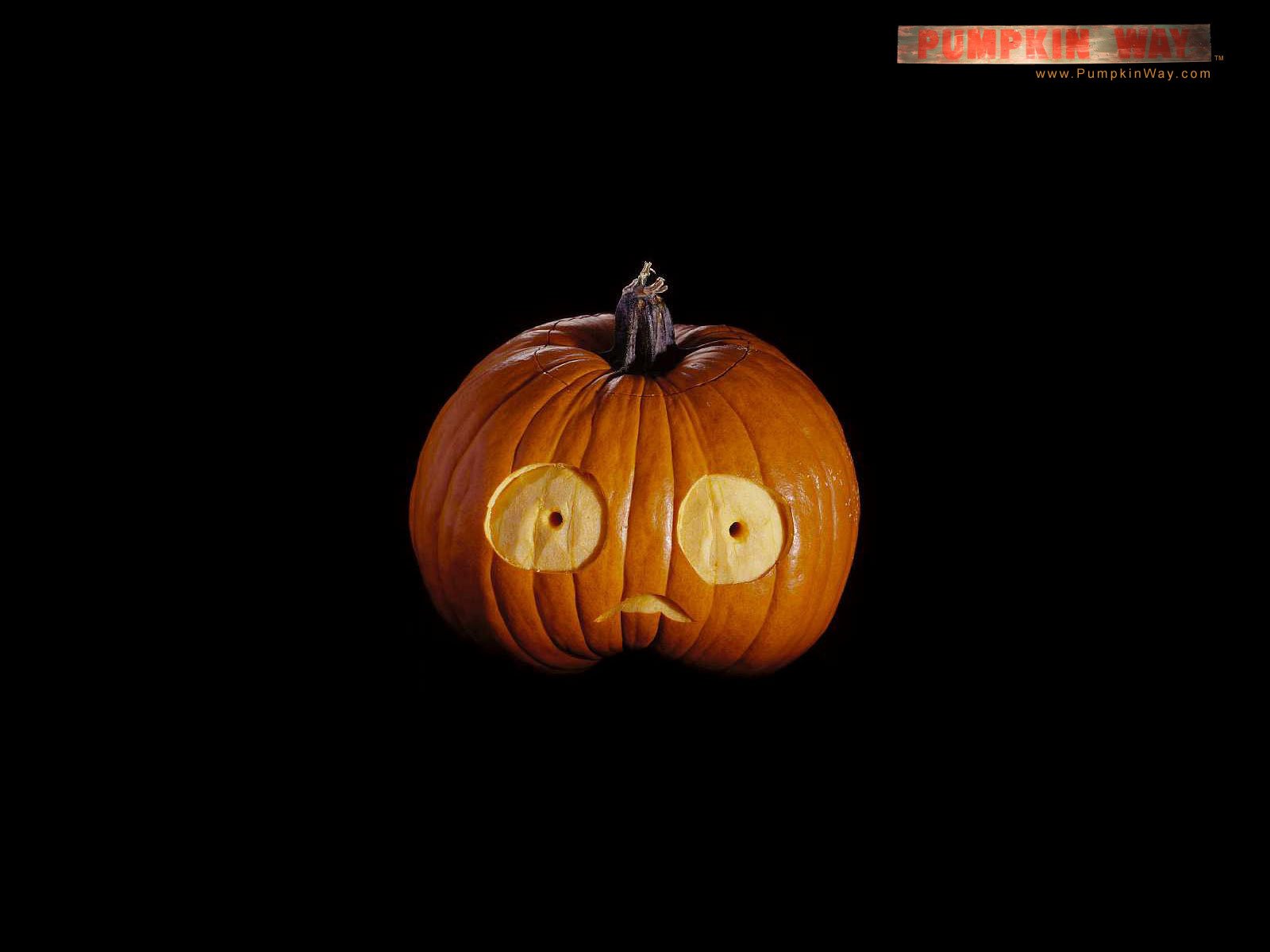HD PC desktop wallpaper featuring a carved pumpkin with round eyes, set against a black background for Halloween holiday ambiance.