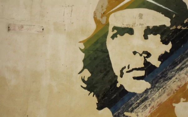 A powerful HD wallpaper featuring a military-themed mural of Che Guevara, showcasing his iconic image against a textured background in earthy tones.