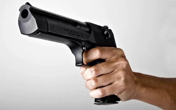 A close-up view of a hand holding a Desert Eagle handgun, set against a minimalist background, serving as a striking HD PC desktop wallpaper.