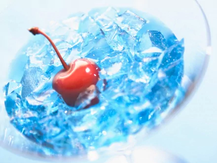 Artistic HD PC desktop wallpaper featuring a vibrant red cherry resting on a bed of bright blue crushed ice.