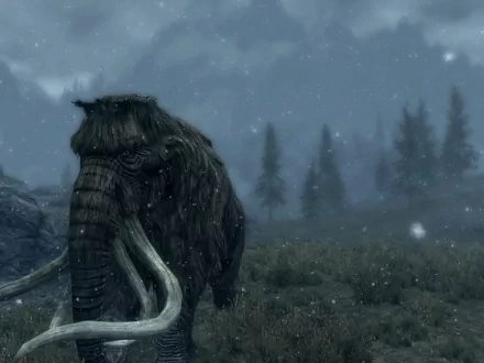 A mammoth stands in a snowy landscape from The Elder Scrolls V: Skyrim, surrounded by trees, creating a captivating scene for an HD PC desktop wallpaper.