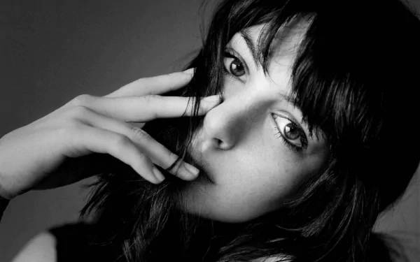 A high-definition black and white wallpaper featuring a close-up of actress Anne Hathaway, showcasing her expressive eyes and thoughtful gesture.