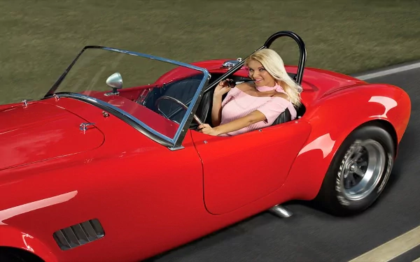 A stylish woman drives a classic red convertible car, exuding confidence and elegance. This HD wallpaper captures the vibrant energy of girls and cars.