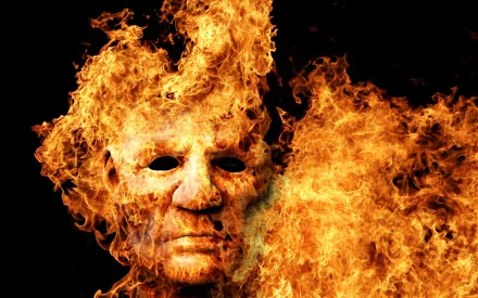 An artistic HD wallpaper featuring a fiery face engulfed in flames, creating a striking and intense visual background.
