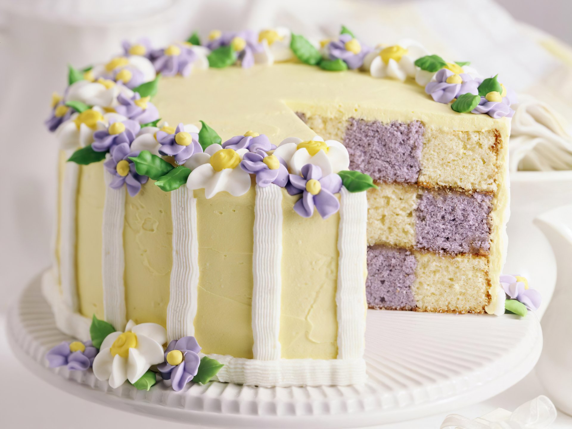 A beautifully decorated cake with delicate flowers sits on a display, showcasing its vibrant layered interior. This high-definition image serves as a stunning PC desktop wallpaper.