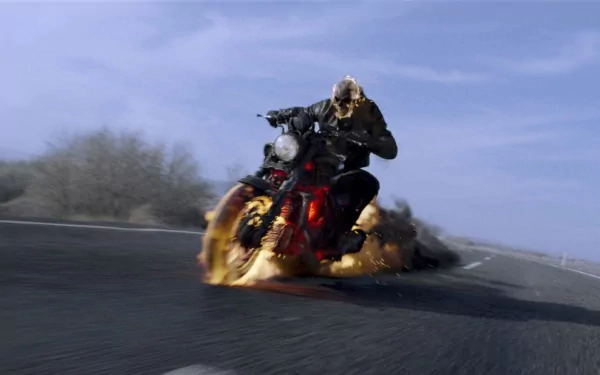 HD PC desktop wallpaper featuring Ghost Rider: Spirit of Vengeance riding a fiery motorcycle on a curved road against a clear blue sky.