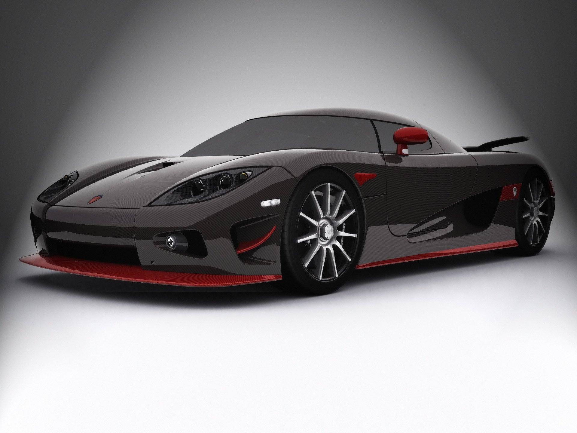 HD PC desktop wallpaper featuring a sleek dark gray Koenigsegg vehicle — a hypercar with red accents, low stance and polished alloy wheels on a soft gradient background.