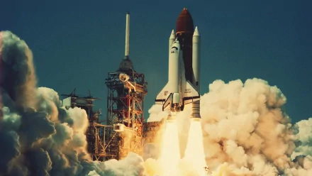 A stunning HD wallpaper featuring the Space Shuttle Challenger launching into space, surrounded by billowing clouds of smoke and vapor, capturing the power of this iconic space vehicle.