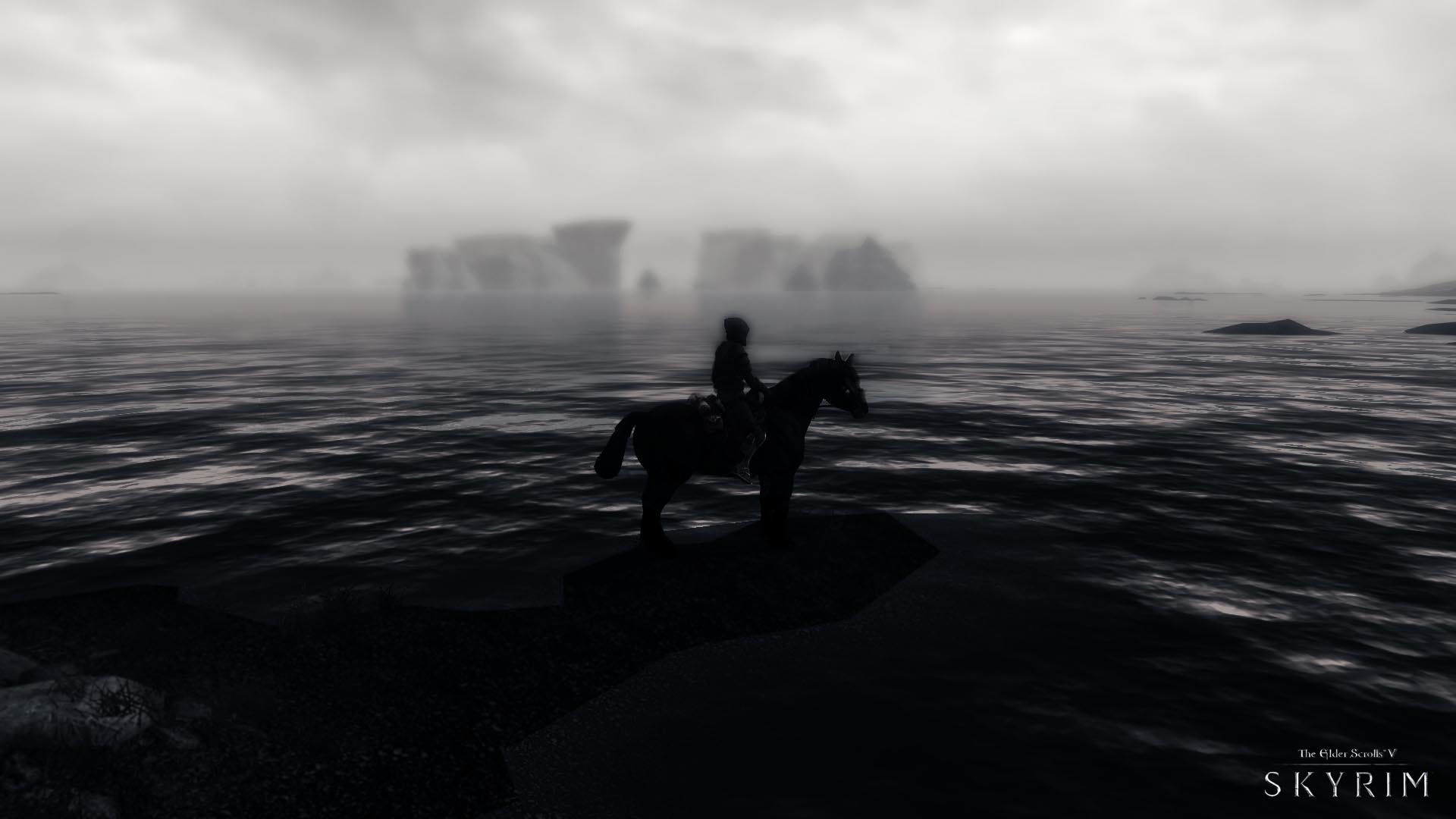 A HD PC desktop wallpaper from The Elder Scrolls V: Skyrim featuring a lone rider on horseback standing on a rocky shore against a foggy, atmospheric backdrop.