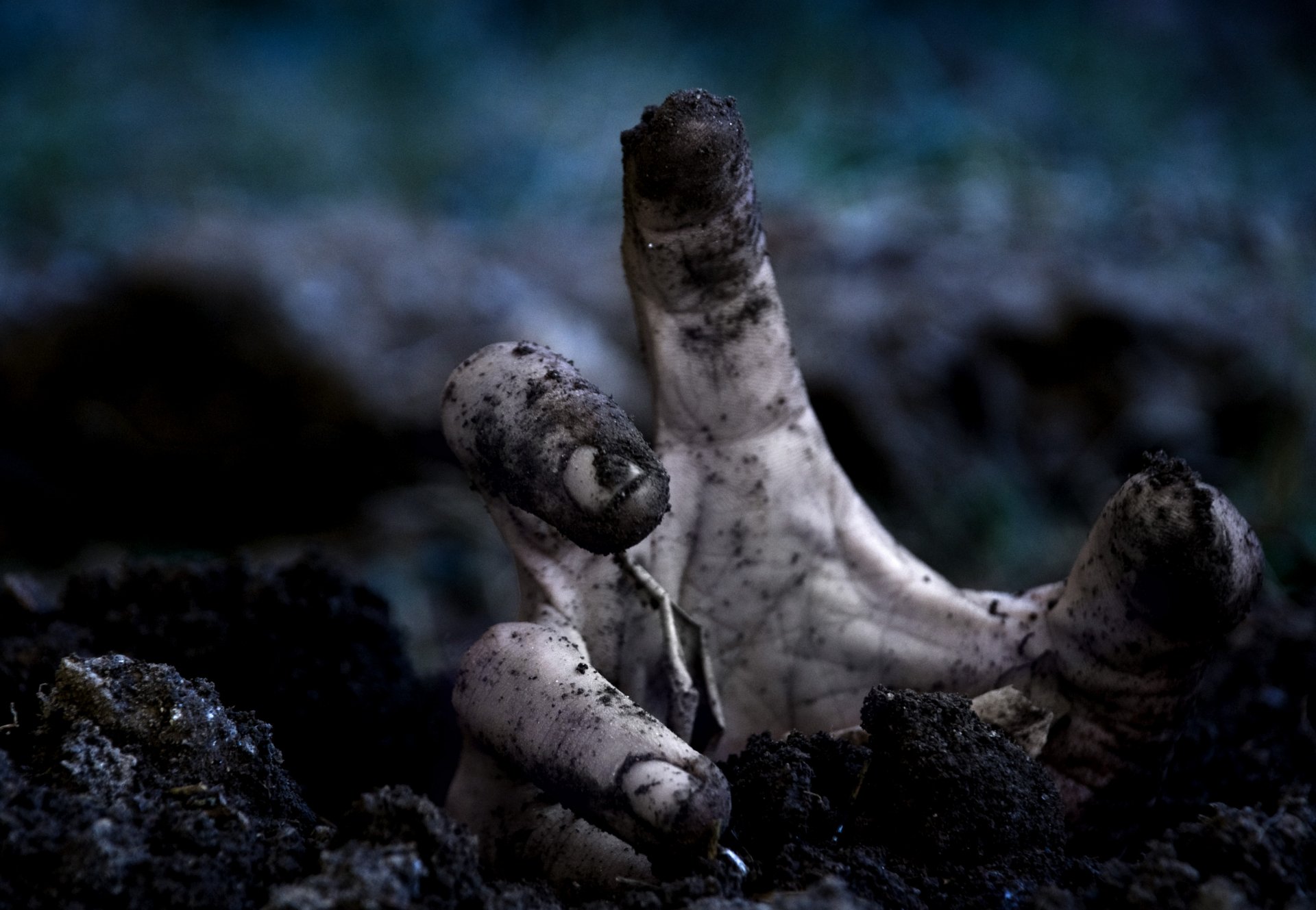 HD PC desktop wallpaper featuring a dark, eerie scene with a decayed zombie hand emerging from the ground.