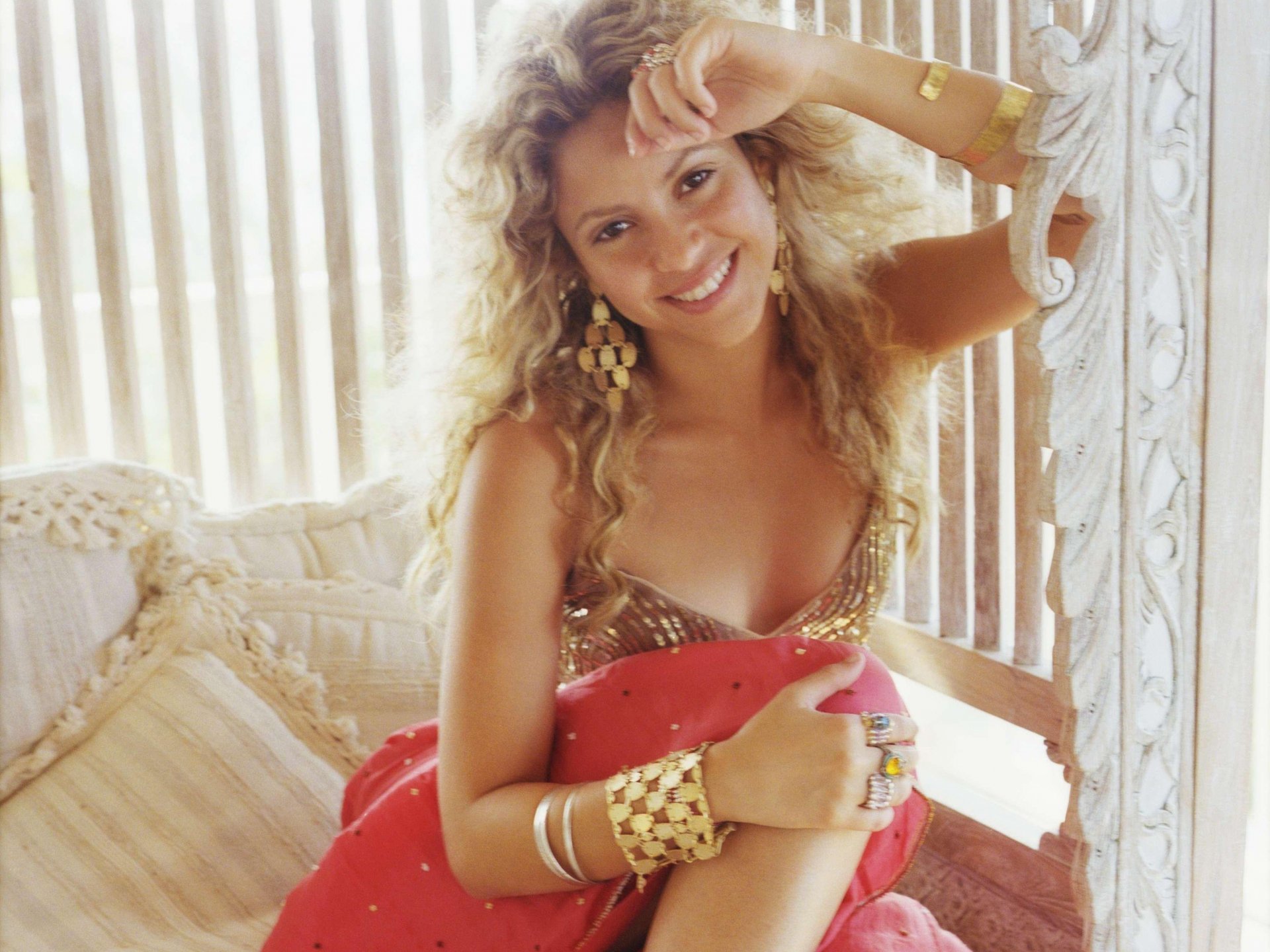 HD PC desktop wallpaper featuring Shakira smiling in a relaxed pose, highlighting her music career and vibrant personality.