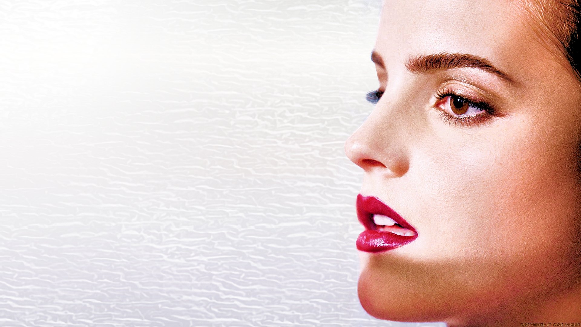 HD desktop wallpaper featuring a close-up profile of Emma Watson with bold red lipstick against a textured light background.