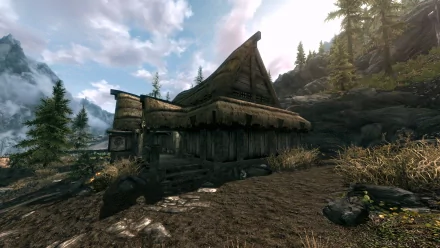 HD PC desktop wallpaper from The Elder Scrolls V: Skyrim showing a Falkreath thatched cabin among pine trees and rocky hills beneath a cloudy sky.