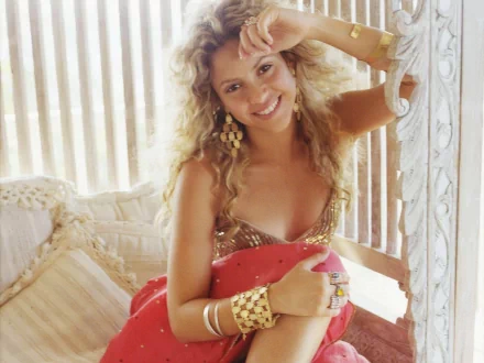 HD PC desktop wallpaper featuring Shakira smiling in a relaxed pose, highlighting her music career and vibrant personality.