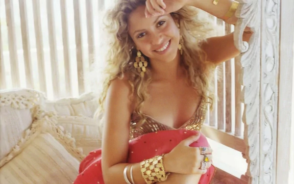HD PC desktop wallpaper featuring Shakira smiling in a relaxed pose, highlighting her music career and vibrant personality.