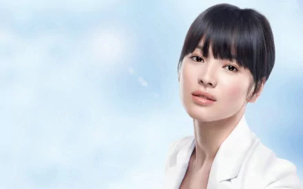 A high-definition wallpaper featuring Song Hye Kyo, a renowned Korean actress. The image captures her elegant beauty against a soft blue background, showcasing her as a celebrated Asian celebrity.