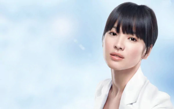 A high-definition wallpaper featuring Song Hye Kyo, a renowned Korean actress. The image captures her elegant beauty against a soft blue background, showcasing her as a celebrated Asian celebrity.