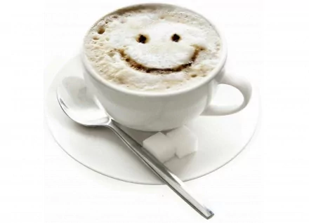 A cheerful cup of coffee with a smiley face drawn in the foam, accompanied by a spoon and sugar cubes, set against a clean white background for an uplifting HD desktop wallpaper.