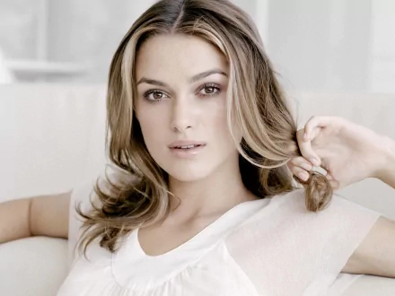 HD desktop wallpaper featuring celebrity Keira Knightley, with a serene expression, wearing a white top against a soft, light background.