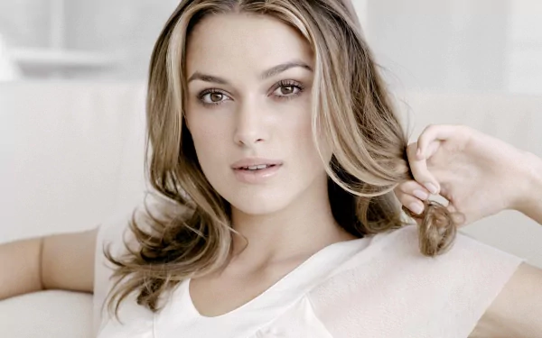 HD desktop wallpaper featuring celebrity Keira Knightley, with a serene expression, wearing a white top against a soft, light background.