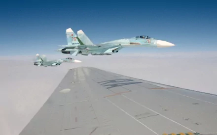A stunning HD wallpaper featuring military Sukhoi Su-27 jets soaring against a clear blue sky, showcasing the power and agility of these aircraft in flight.