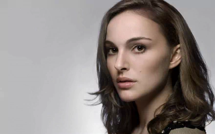 A striking high-definition wallpaper featuring Natalie Portman, showcasing her captivating expression against a soft, neutral background.