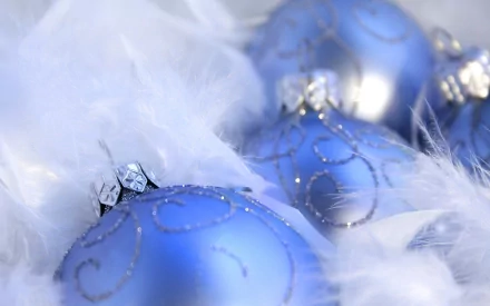 HD PC desktop wallpaper featuring blue Christmas ornaments nestled in soft white feathers, evoking a festive holiday atmosphere.