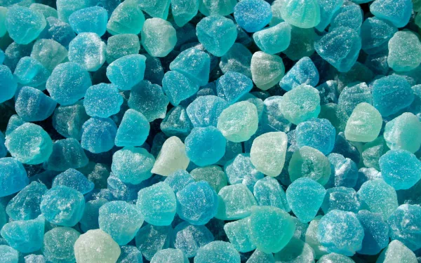 HD PC desktop wallpaper featuring a close-up of blue and teal sugar-coated candy pieces, creating a vibrant and textured food-inspired background.