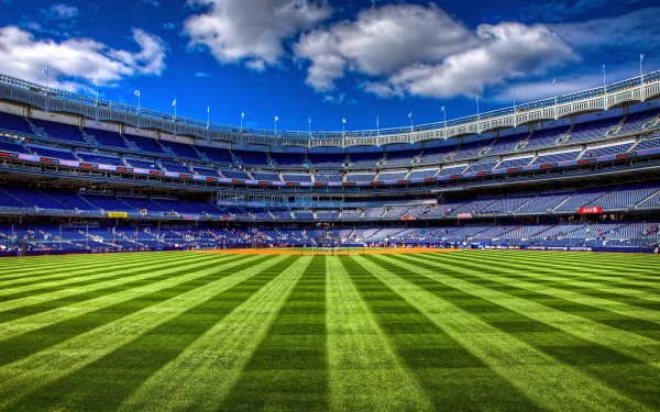 A stunning HD desktop wallpaper featuring a vibrant stadium with perfectly manicured grass and an expansive blue sky, capturing the essence of sports excitement.