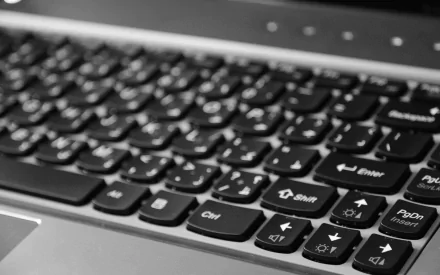 A close-up view of a black laptop keyboard, showcasing its keys and design features, captured in high-definition for a sleek technology-themed wallpaper.