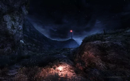 Dear Esther video game HD PC desktop wallpaper/background: moonlit coastal cliffs and a path leading to a distant red-lit lighthouse beneath a starry, stormy night sky.