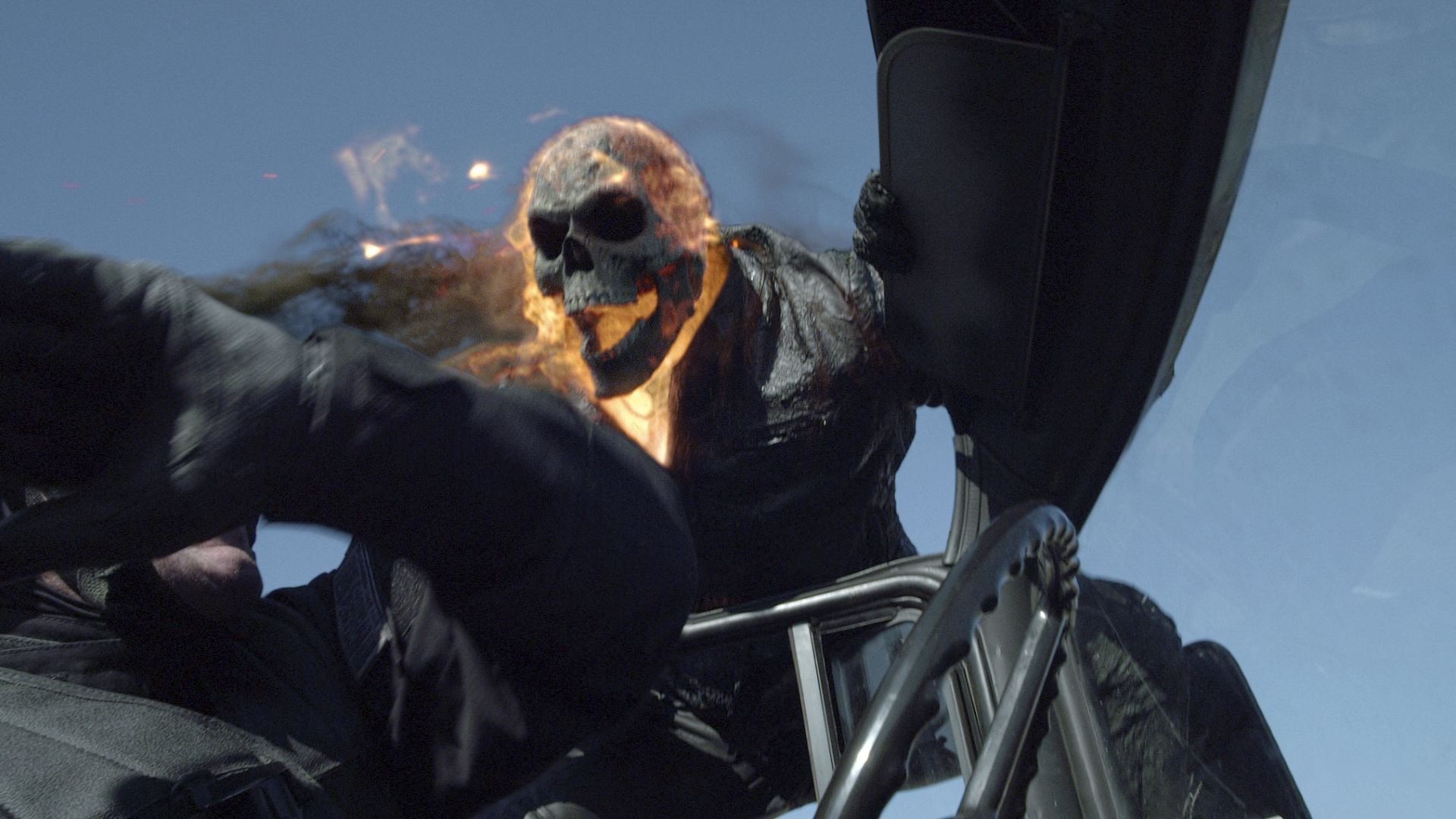 HD PC desktop wallpaper background from the movie Ghost Rider: Spirit of Vengeance — flaming-skulled Ghost Rider lunging on a motorcycle against a clear blue sky.