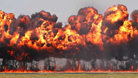 A dramatic explosion creates a fiery backdrop, capturing the intensity of military action. This high-definition image serves as an impactful desktop wallpaper.