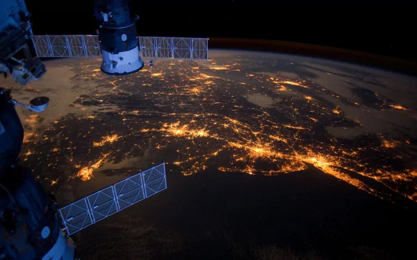 A stunning view of Earth from space, showcasing the International Space Station and illuminated cities at night, captured in vibrant detail for a captivating 4K Ultra HD desktop wallpaper.