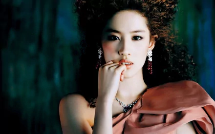 A striking HD wallpaper featuring Liu Yifei, showcasing her elegance with an expressive gaze and glamorous styling against a dramatic background.