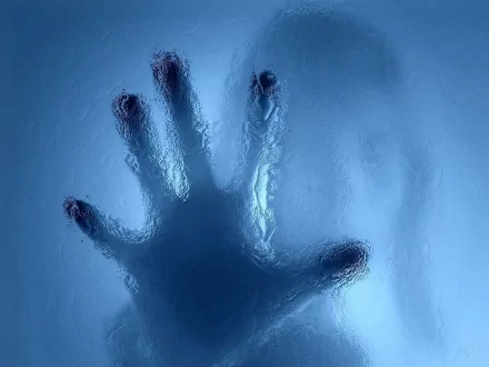 Photography of a silhouetted hand pressed against frosted blue glass, high-definition PC desktop wallpaper and background.