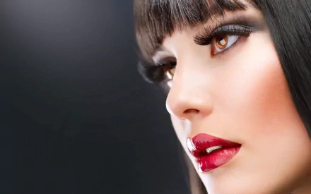 Close-up HD PC desktop wallpaper of a woman with striking makeup and glossy red lips, identified as Judy Wilkins, against a dark background.