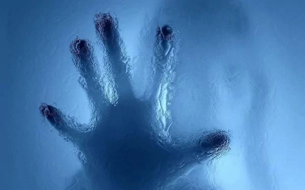 Photography of a silhouetted hand pressed against frosted blue glass, high-definition PC desktop wallpaper and background.