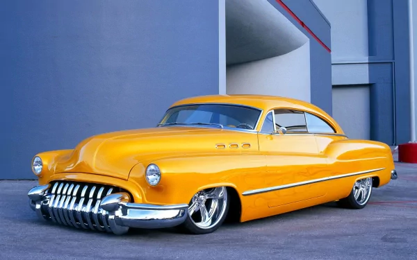 A striking yellow vintage Cadillac parked against a modern backdrop, showcased in high definition for an eye-catching desktop wallpaper and background.