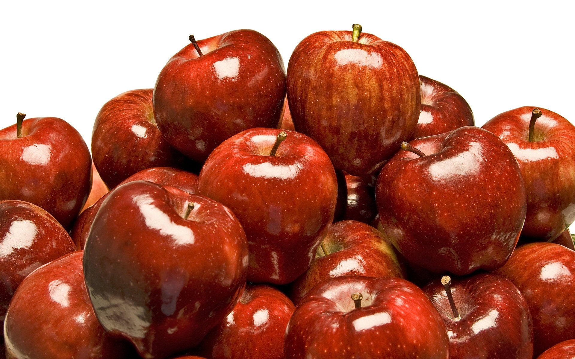 HD PC desktop wallpaper showing a close-up pile of glossy red apples on a white background.