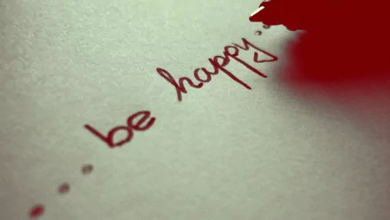 A close-up of a pen writing be happy on paper, conveying a motivational message of love and positivity. This HD desktop wallpaper inspires joy and encouragement.