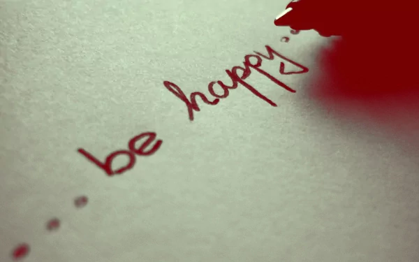 A close-up of a pen writing be happy on paper, conveying a motivational message of love and positivity. This HD desktop wallpaper inspires joy and encouragement.