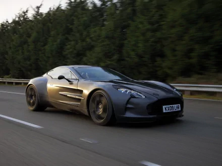 A sleek Aston Martin One-77 speeding on a road, captured in this HD PC desktop wallpaper and background.