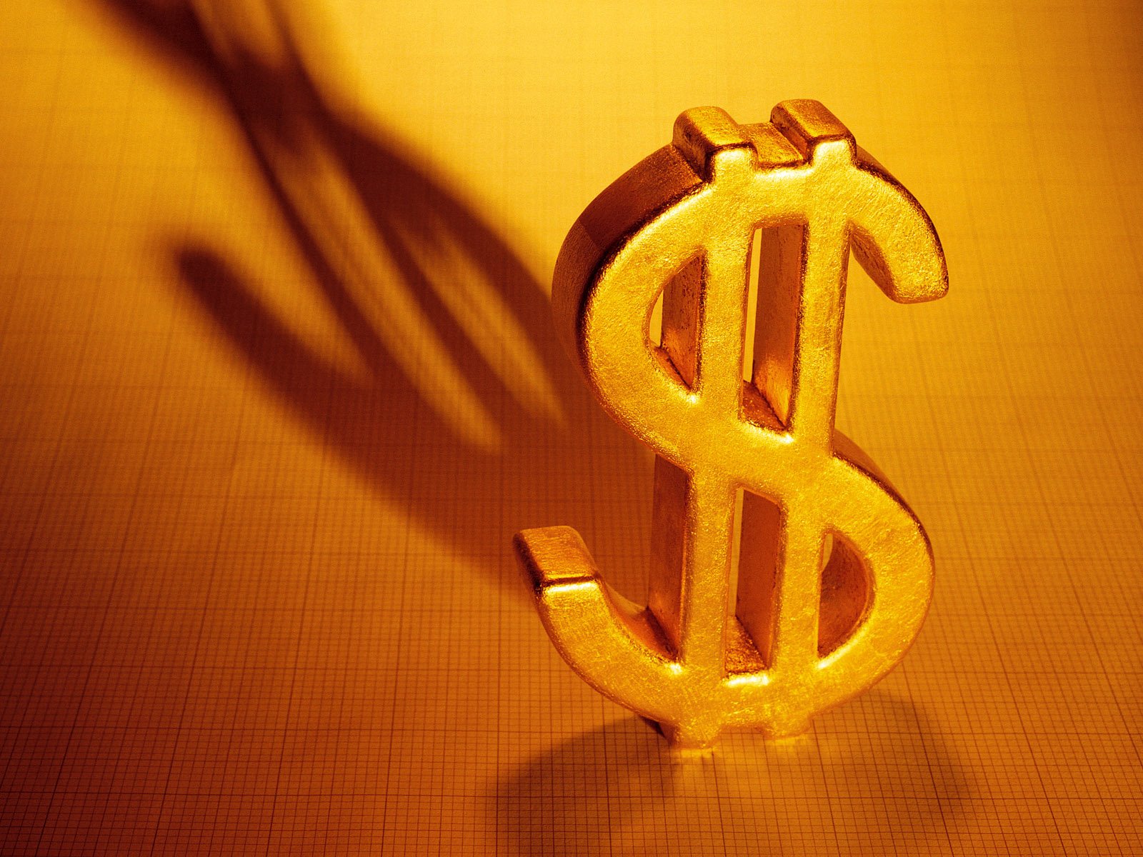 A striking HD desktop wallpaper featuring a gleaming gold dollar sign, casting a distinct shadow against a warm background, symbolizing wealth and prosperity.