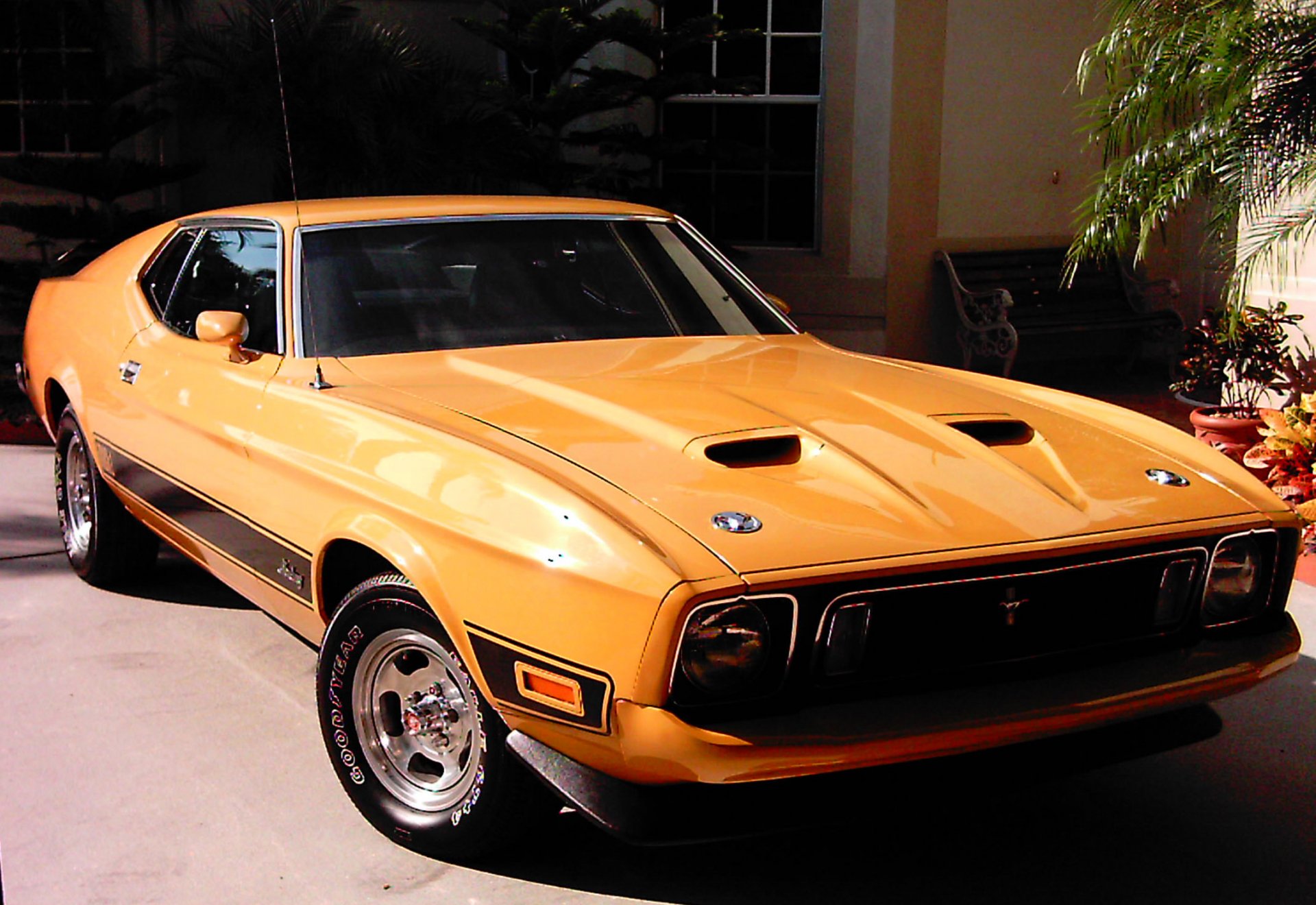 HD desktop wallpaper featuring a classic orange Ford vehicle parked in a shaded outdoor setting.