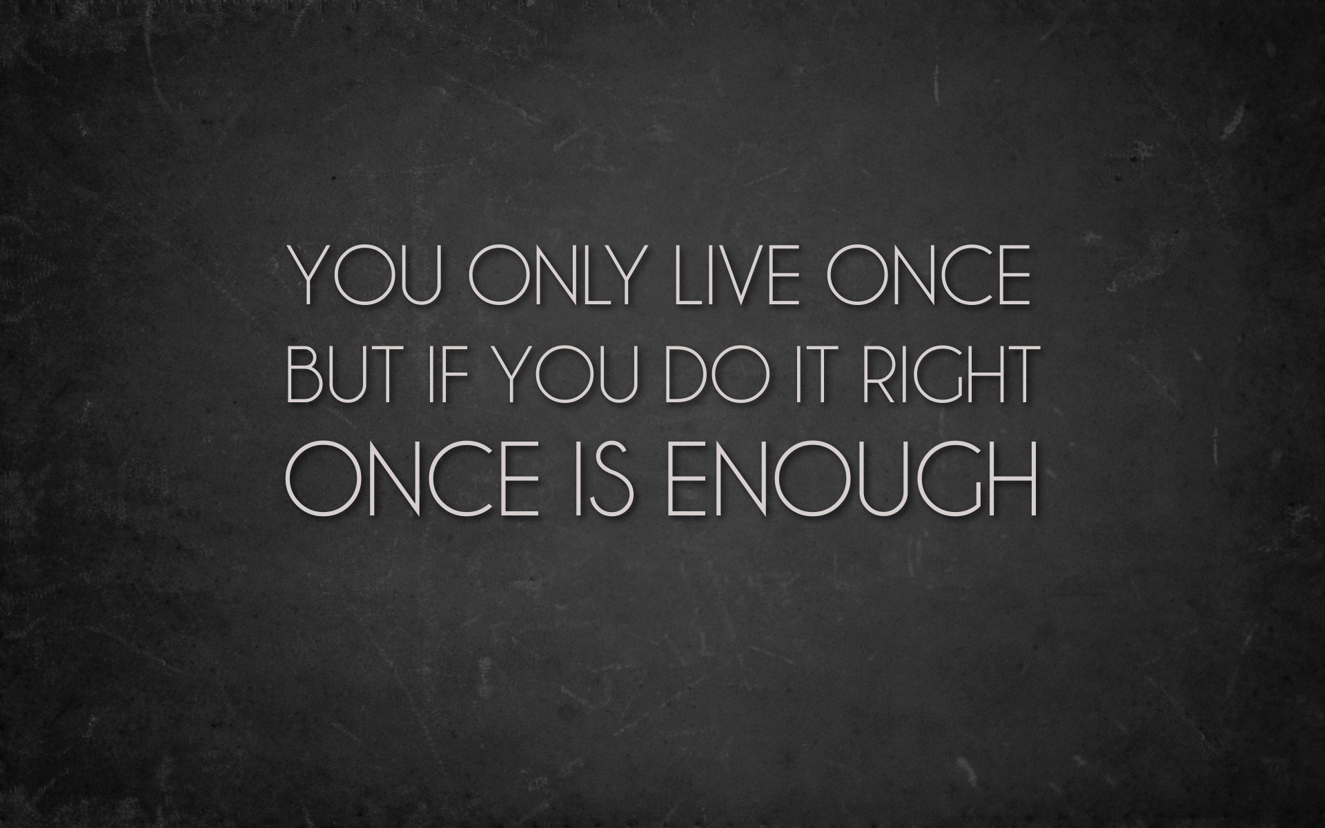 Inspirational quote desktop wallpaper featuring the phrase: You only live once, but if you do it right, once is enough, set against a textured dark background.